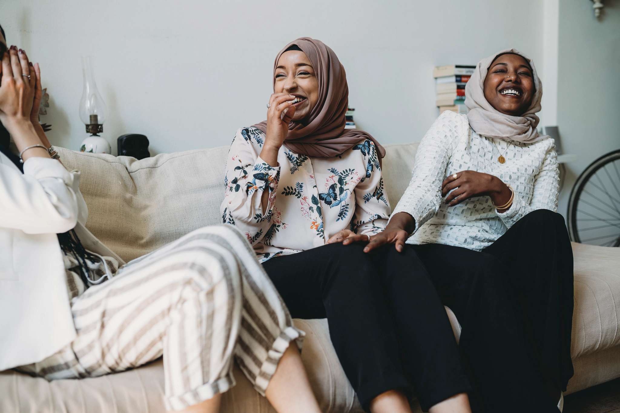 Muslim women sitting on couch and laughing